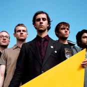 Band Maximo Park with blue sky background, singer holding a yellow object